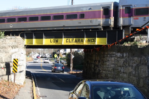 Low-Clearance Bridge near Downey Elementary School
This figure is an image showing a street with a narrow sidewalk passing under a commuter rail overpass. The words “Low Clearance” are stenciled on the overpass.
